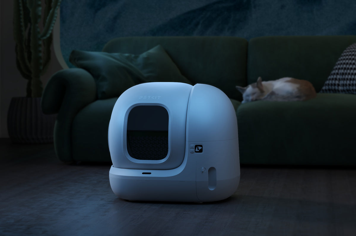 PETKIT PuraMax 2 automatic litter box illuminated in a bedroom at night